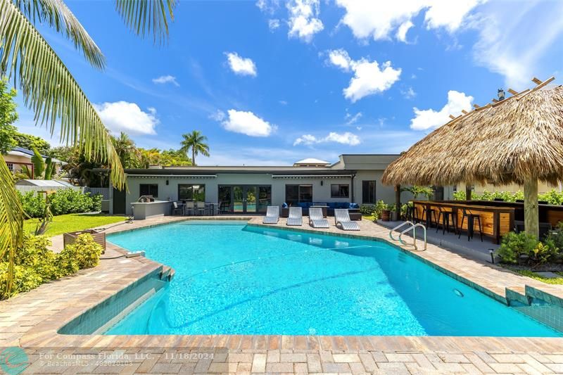 a view of a house with swimming pool and sitting area