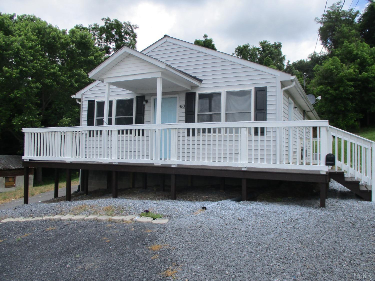 a view of a house with a wooden deck and a yard