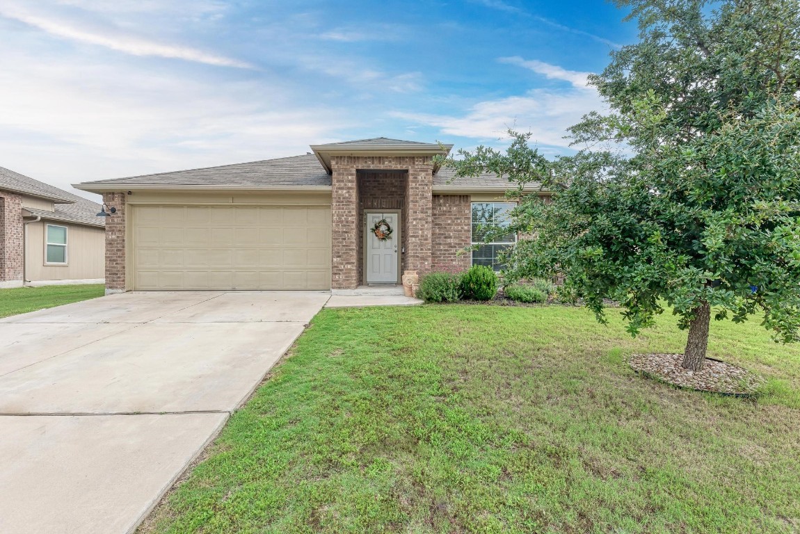 a front view of a house with a yard and garage