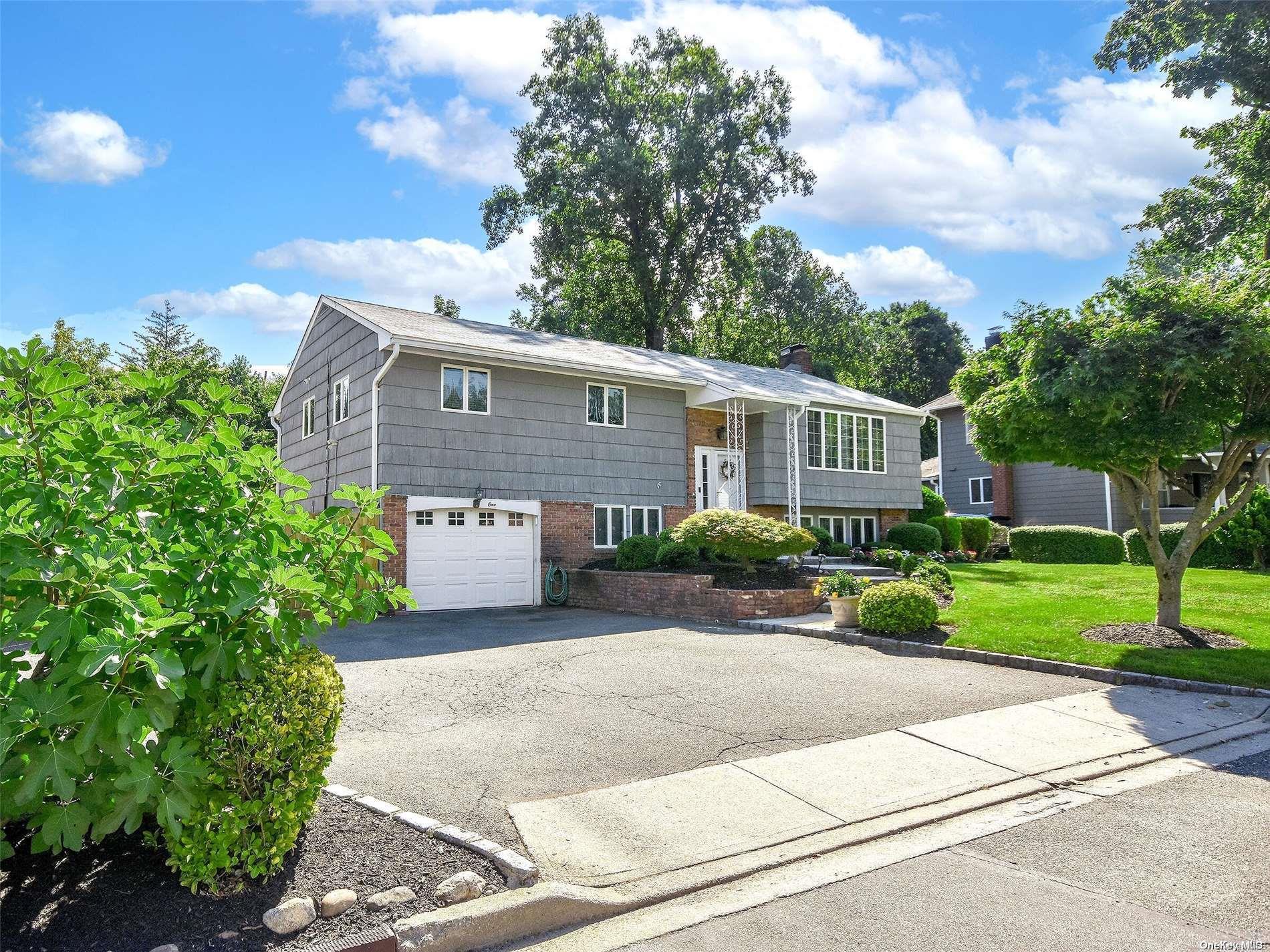 a front view of a house with a yard and trees