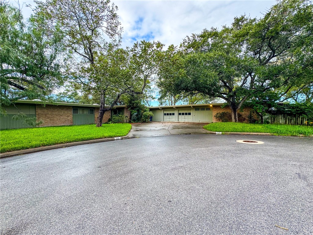 a view of a house with a big yard and large trees