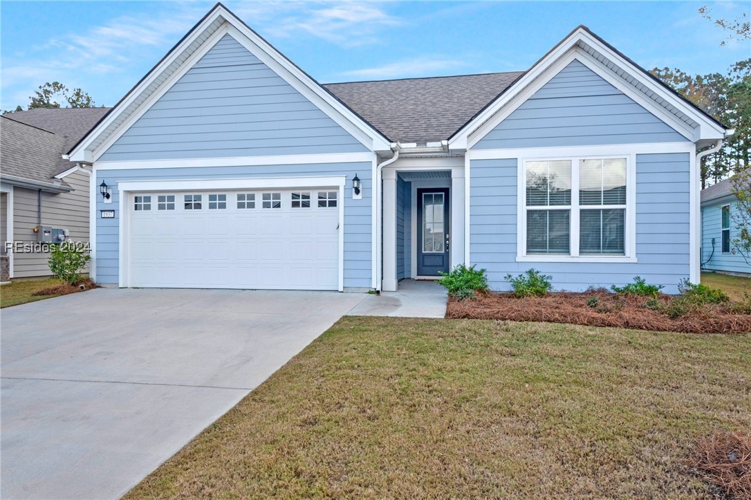 View of front of home with a front yard and a gara