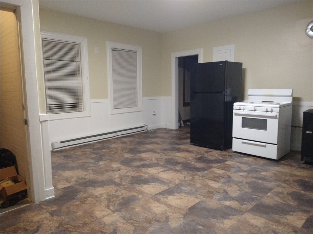 a view of kitchen with refrigerator and cabinets