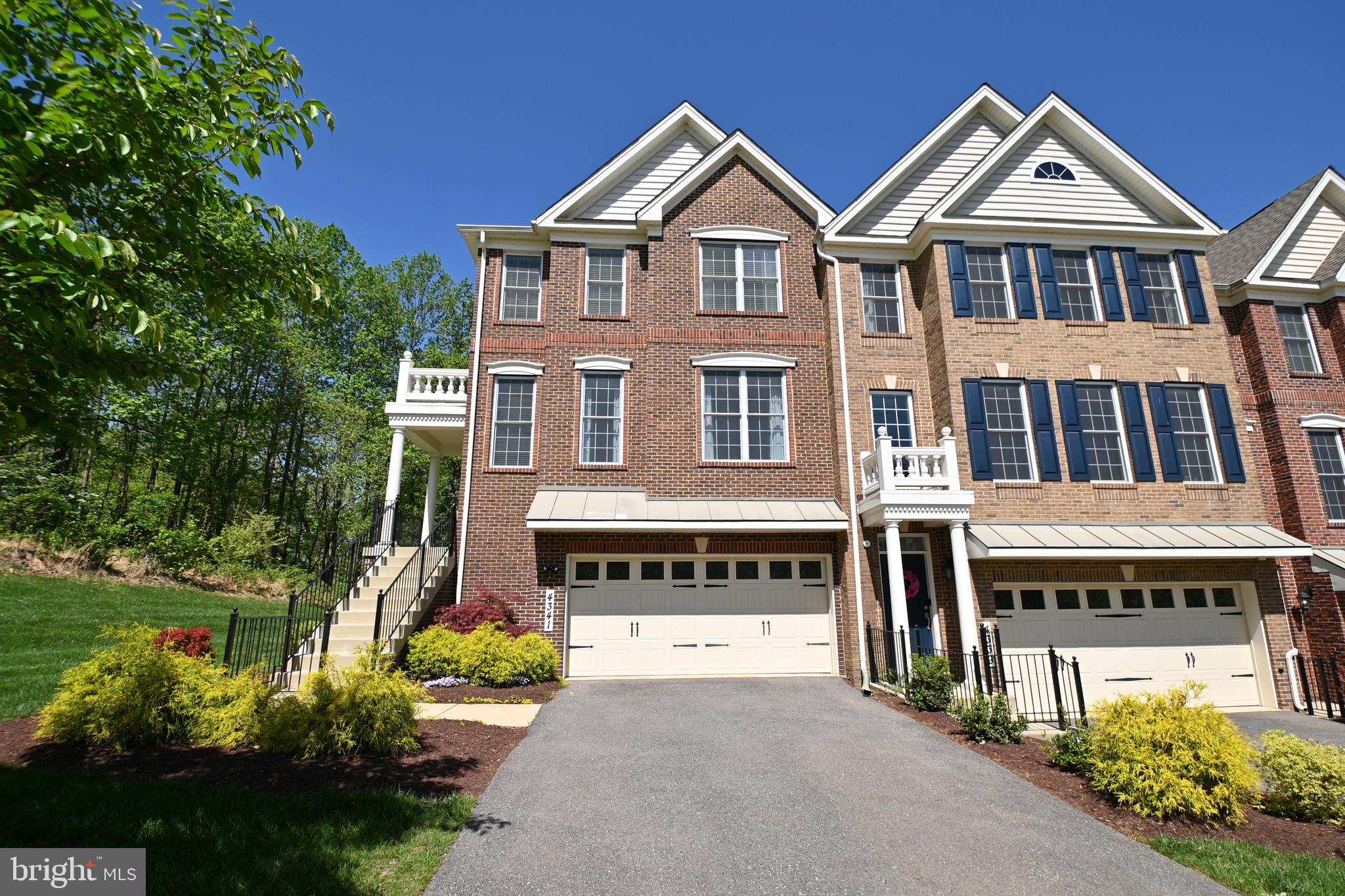 a view of a big house with large windows and a yard with plants and trees