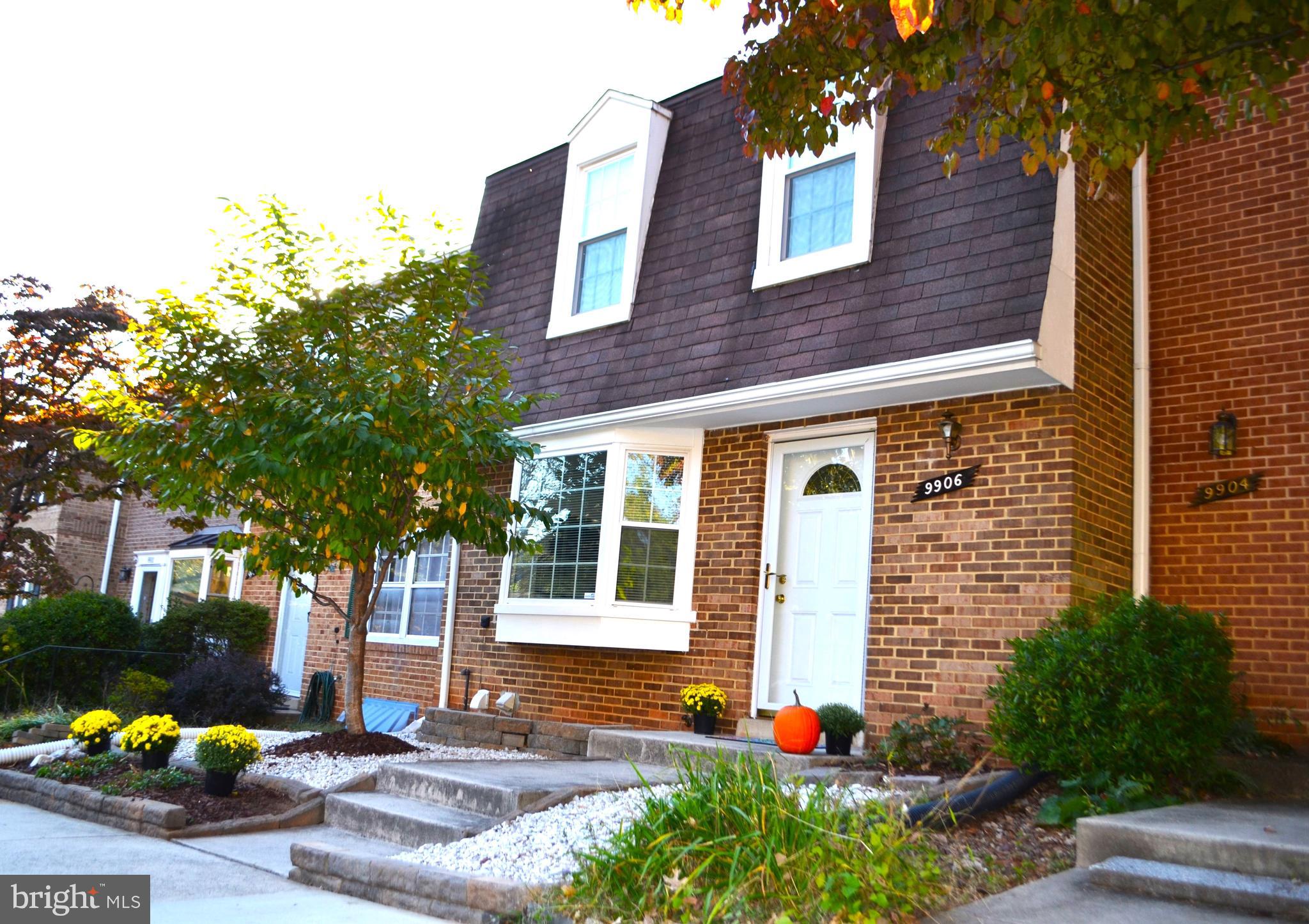 front view of a brick house with a yard