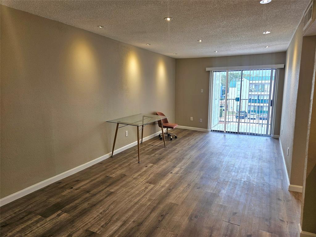 a view of a room with wooden floor and windows