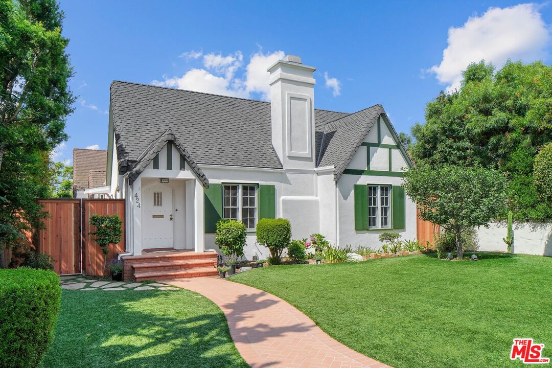 a front view of a house with a garden and plants