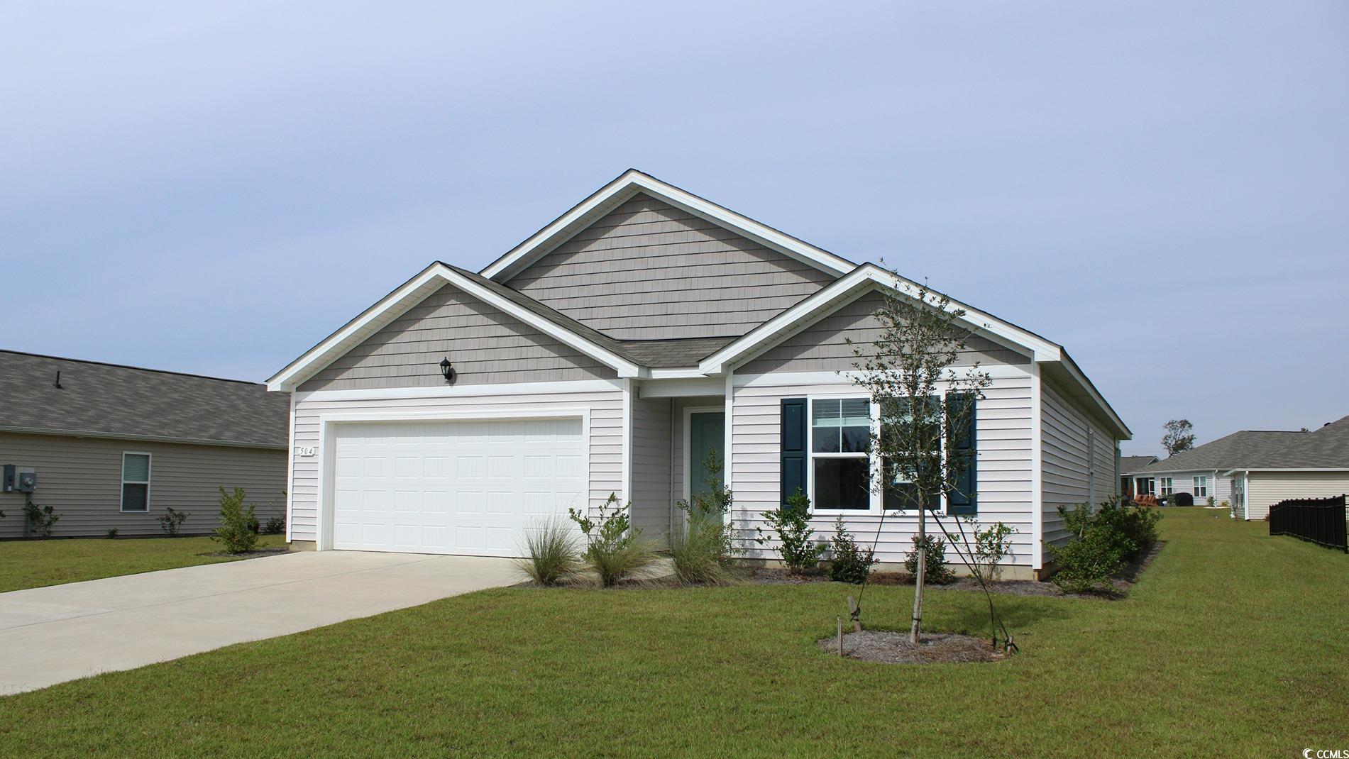 View of front facade with a front yard and a garag