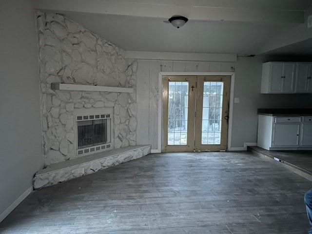 an empty room with windows and fireplace