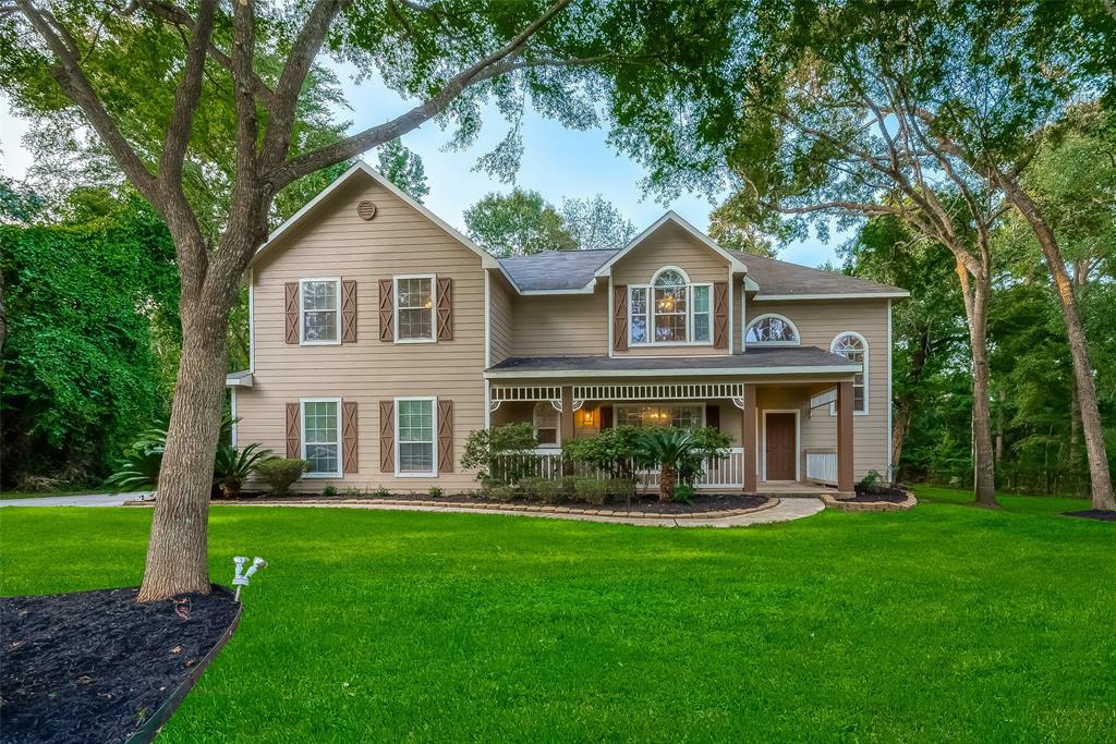 a front view of a house with a yard and green space