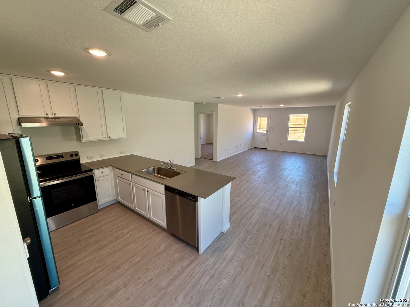 a kitchen with a stove a refrigerator and a sink