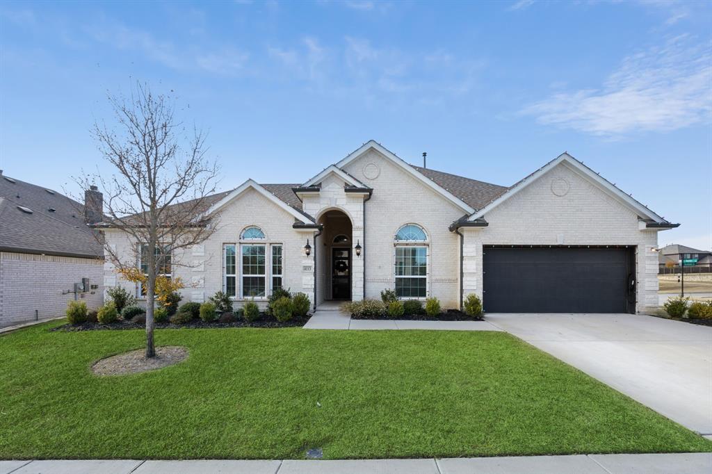 View of front facade with a front yard and a garage