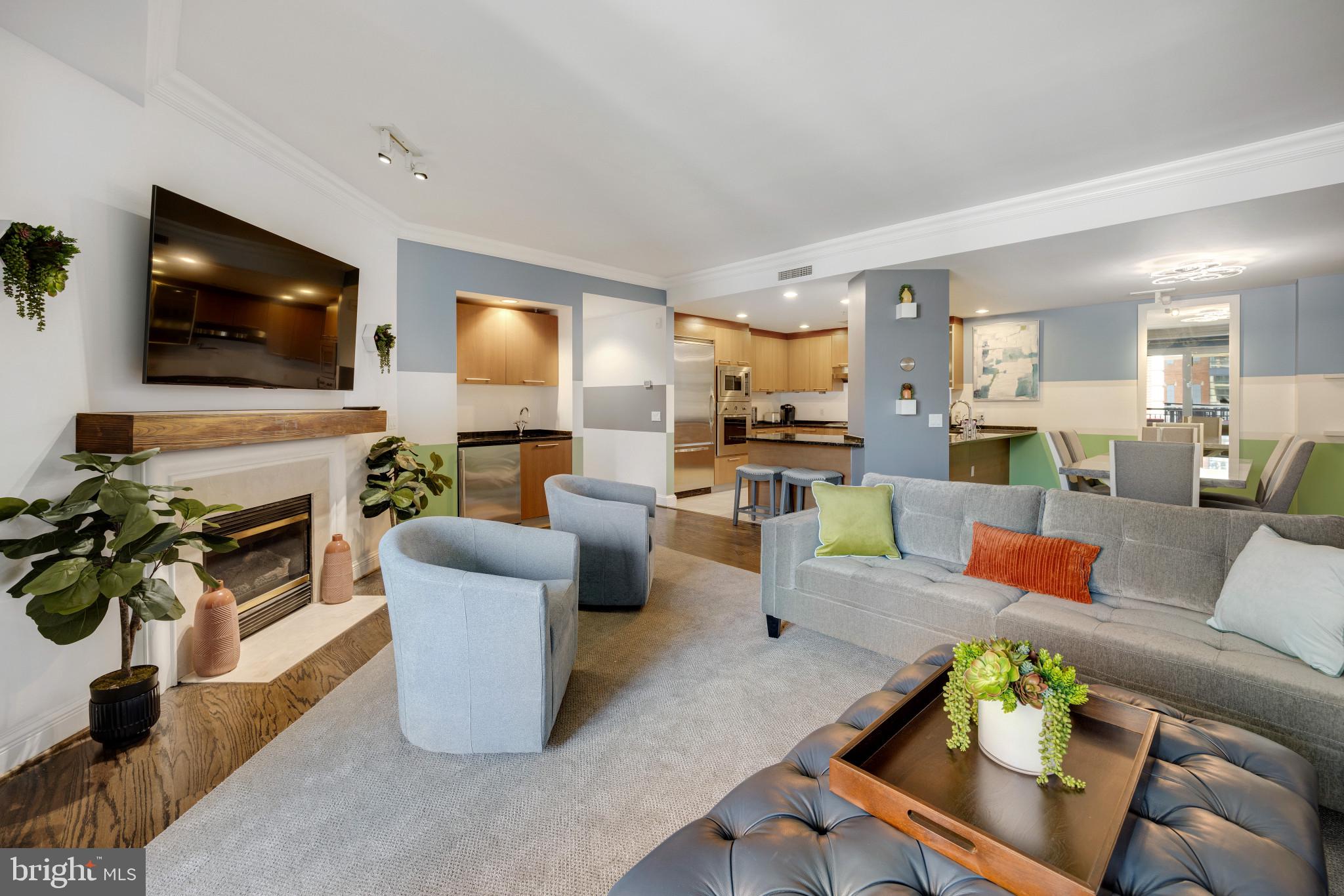 a living room with furniture kitchen view and a flat screen tv