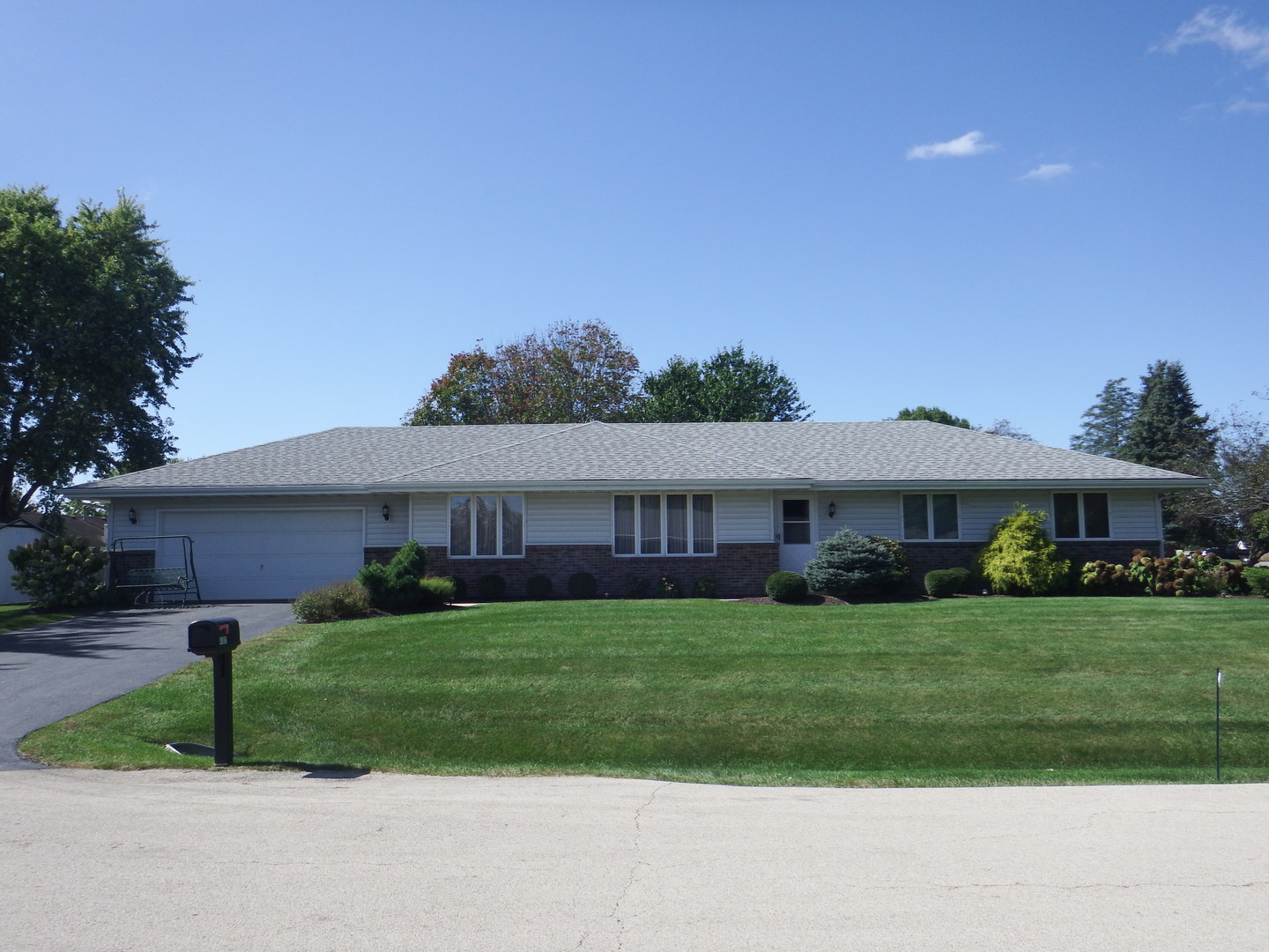 a view of a house with a big yard potted plants and large tree