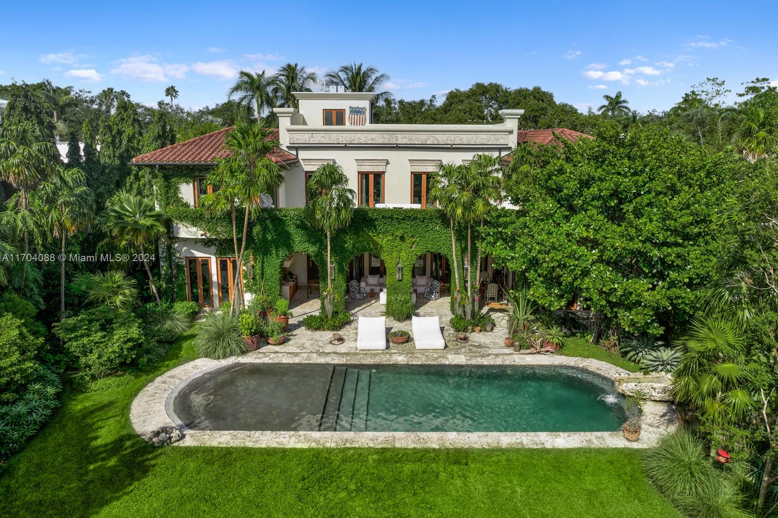 a view of a house with a yard and potted plants