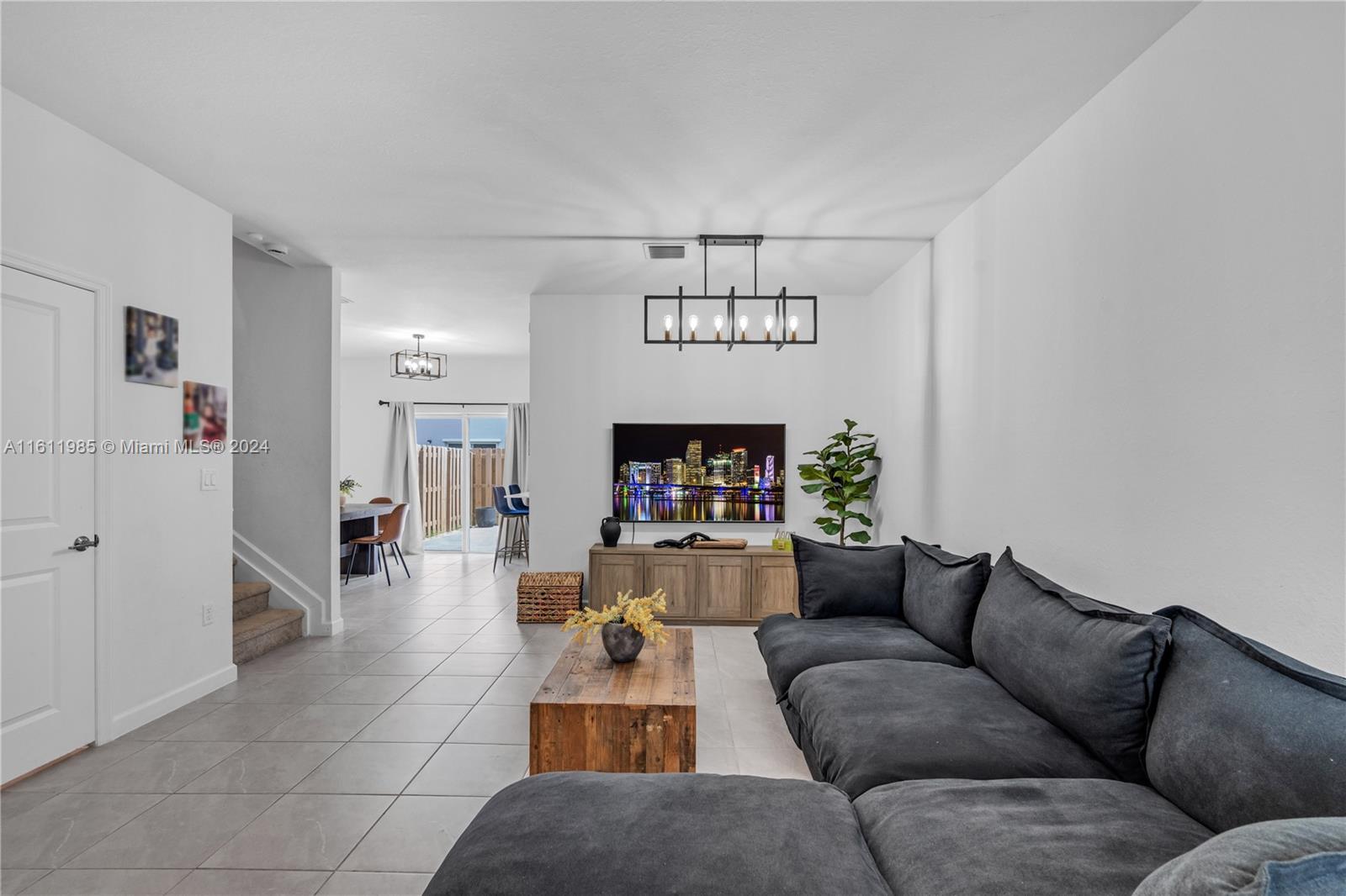 a living room with furniture a chandelier and a wooden floor