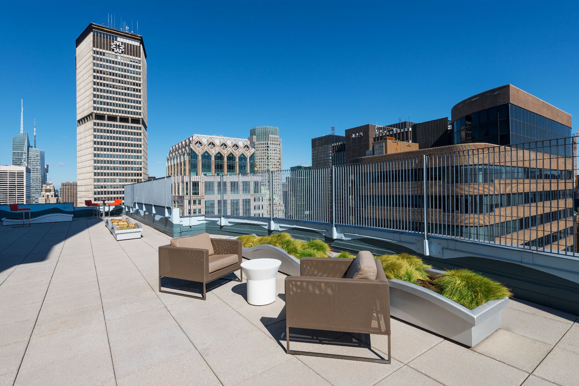 a view of a roof deck with couches and potted plants