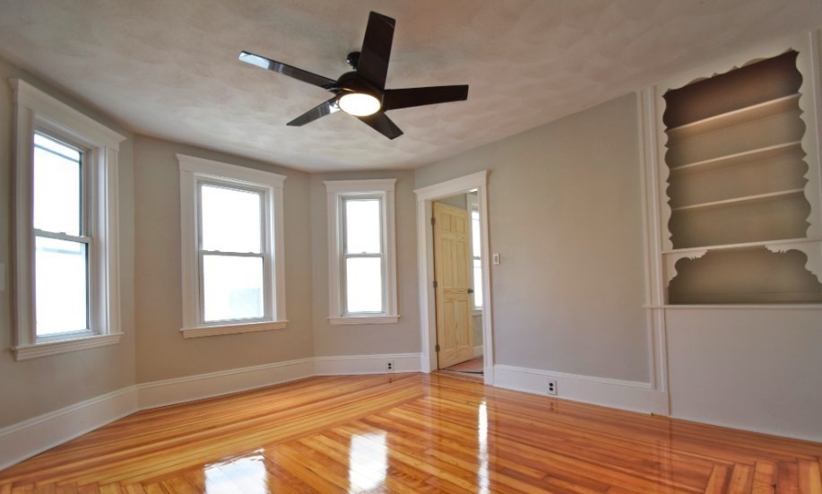 a view of an empty room with a window and closet