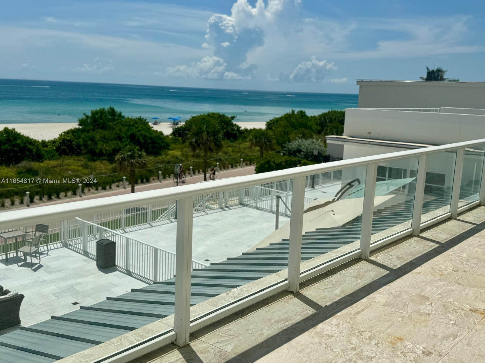 a view of a balcony with floor to ceiling windows yard and ocean view