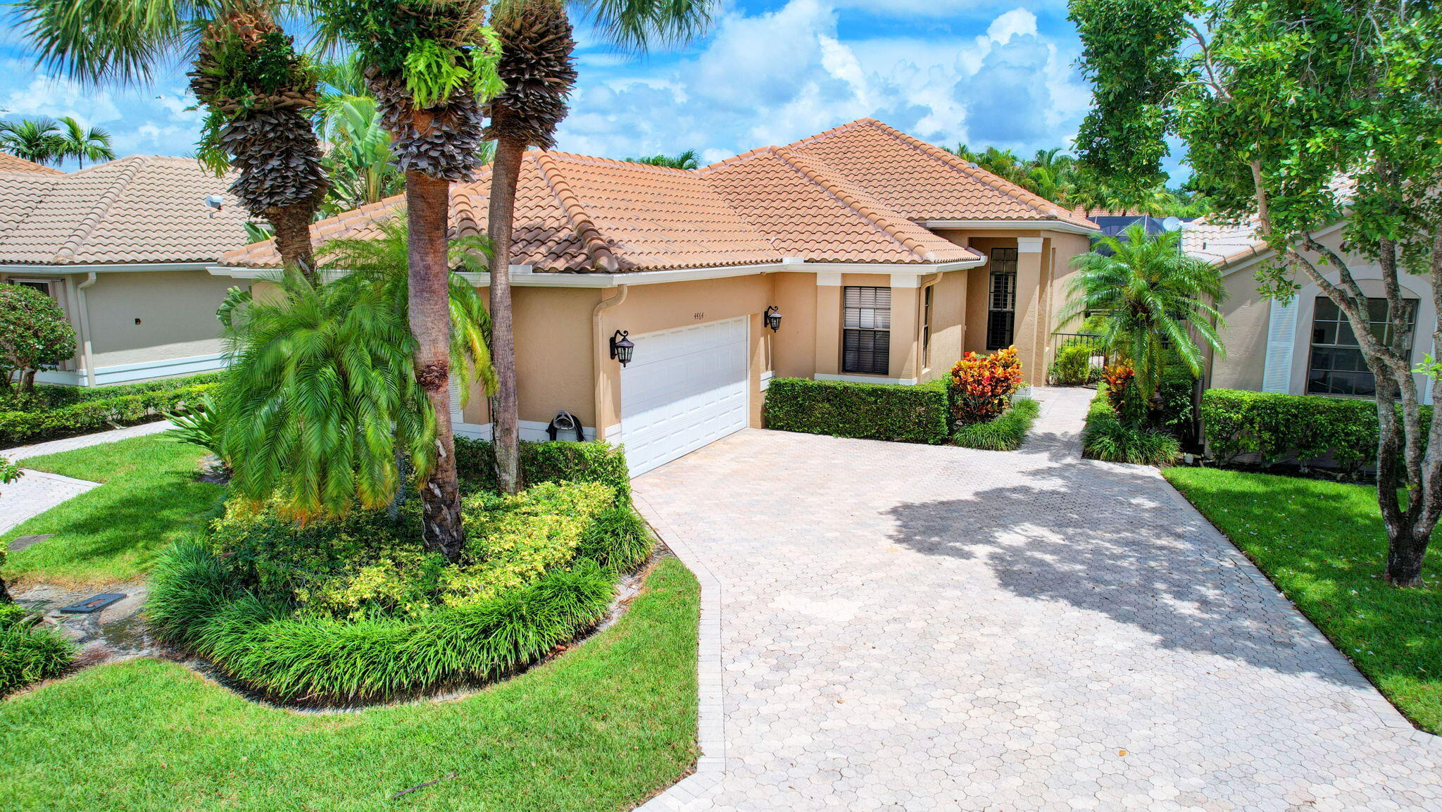 a front view of a house with a yard and potted plants