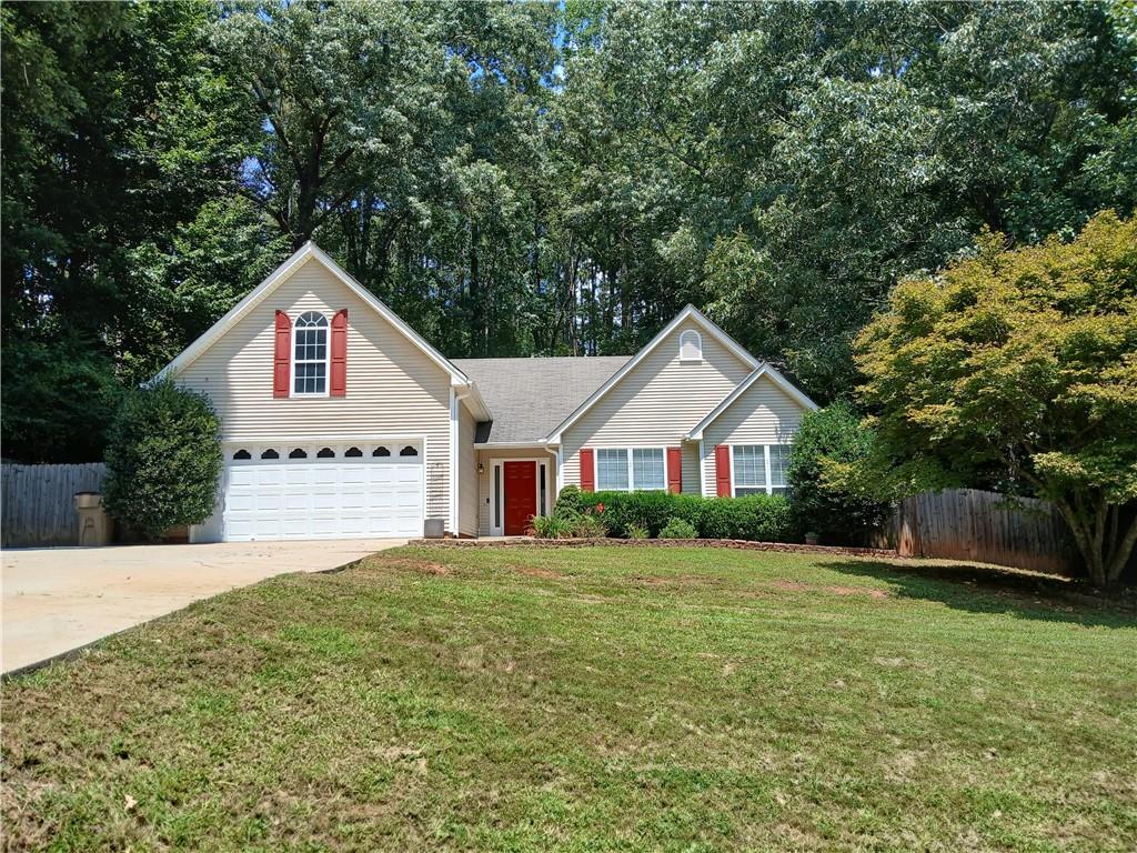 a view of house with yard and trees in the background