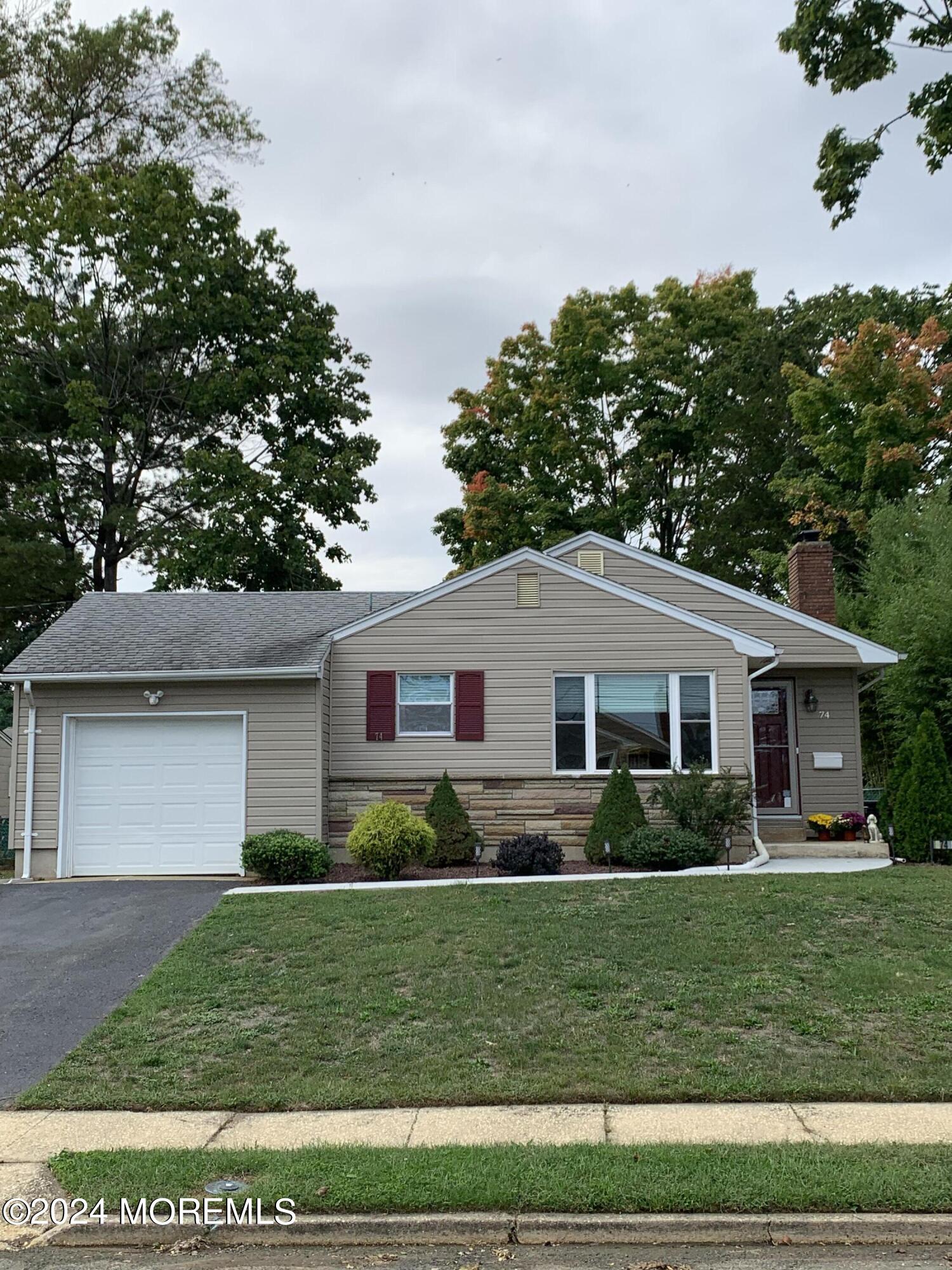 a front view of a house with a garden