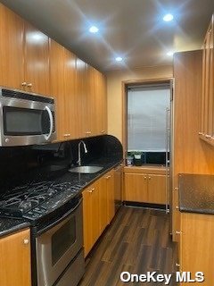 a kitchen with stainless steel appliances a stove a microwave and sink