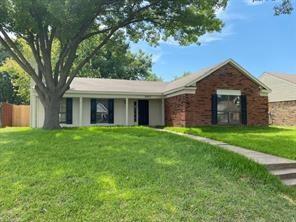 front view of a brick house with a yard