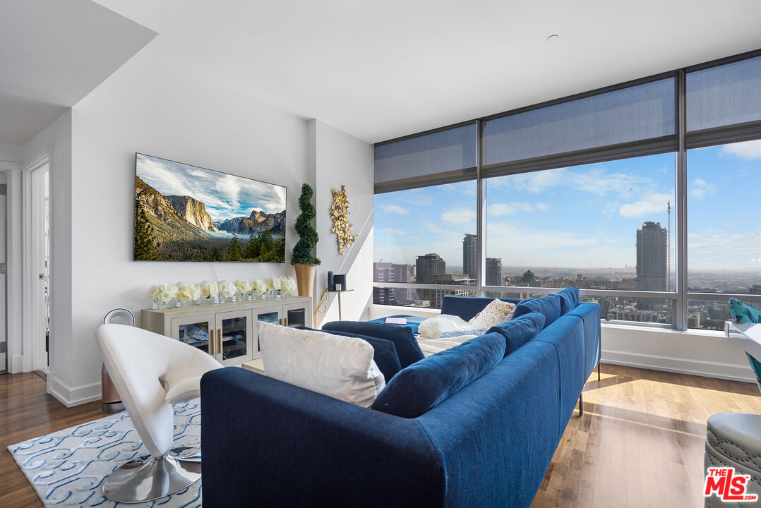 a living room with furniture kitchen view and a large window