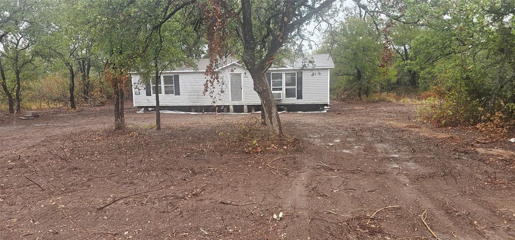 a view of a house with a yard and tree s