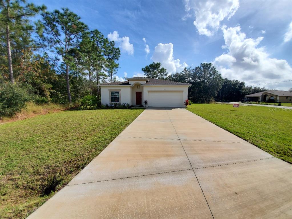 a front view of a house with yard and mountain view