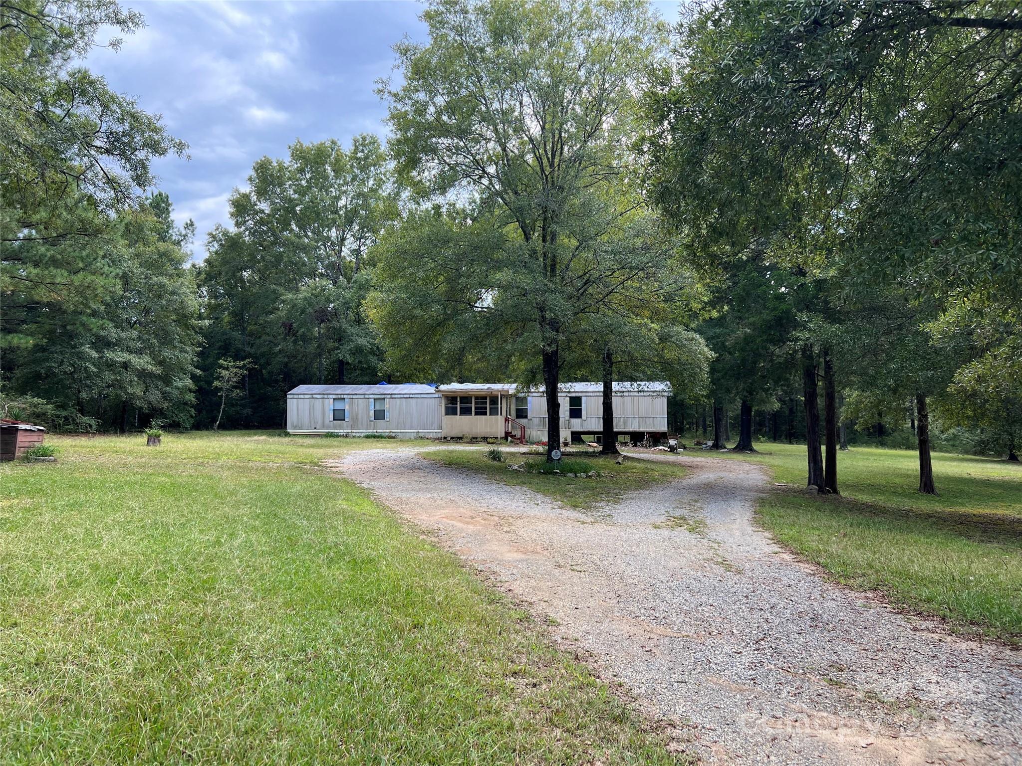 a front view of a house with a yard and trees