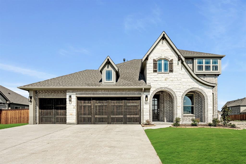 a front view of a house with a garden and yard