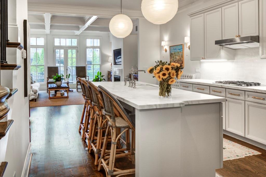 a kitchen with stainless steel appliances granite countertop a stove a sink and a dining table with wooden floor