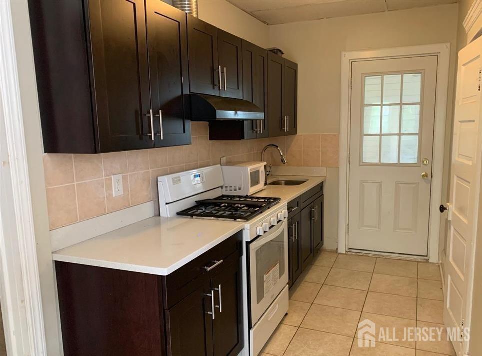 a kitchen with a sink dishwasher stove and cabinets