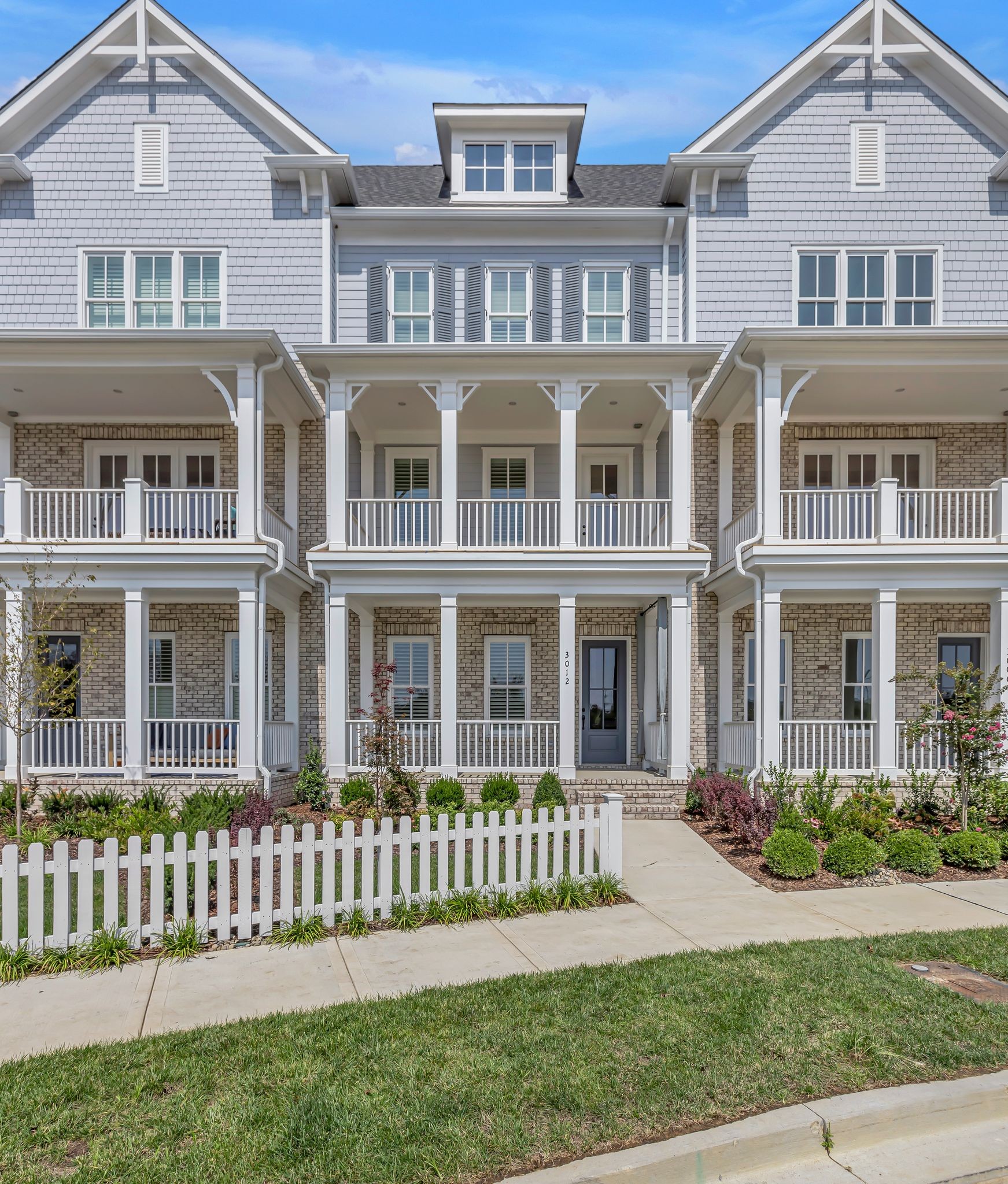 a front view of a residential apartment building with a yard