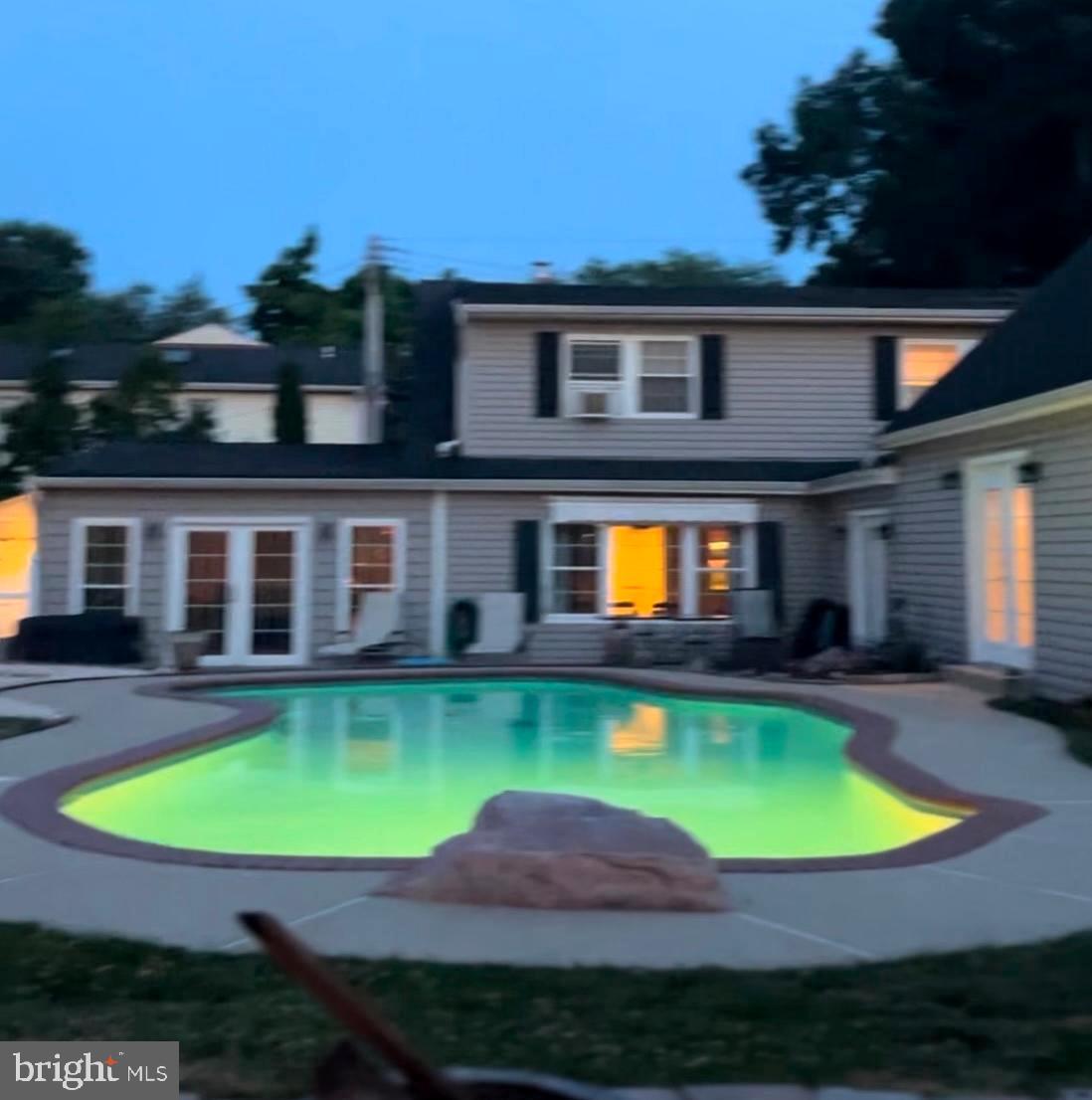 a view of a swimming pool with a yard and plants