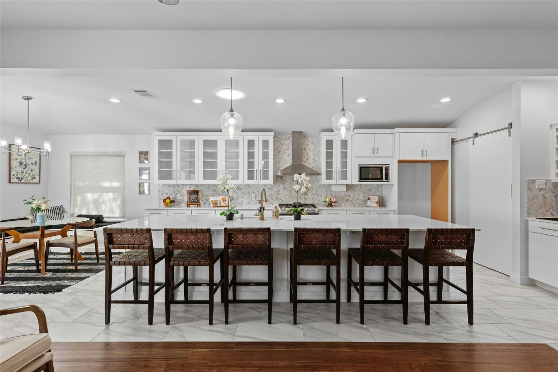 a dining room with stainless steel appliances kitchen island granite countertop a dining table chairs and view kitchen