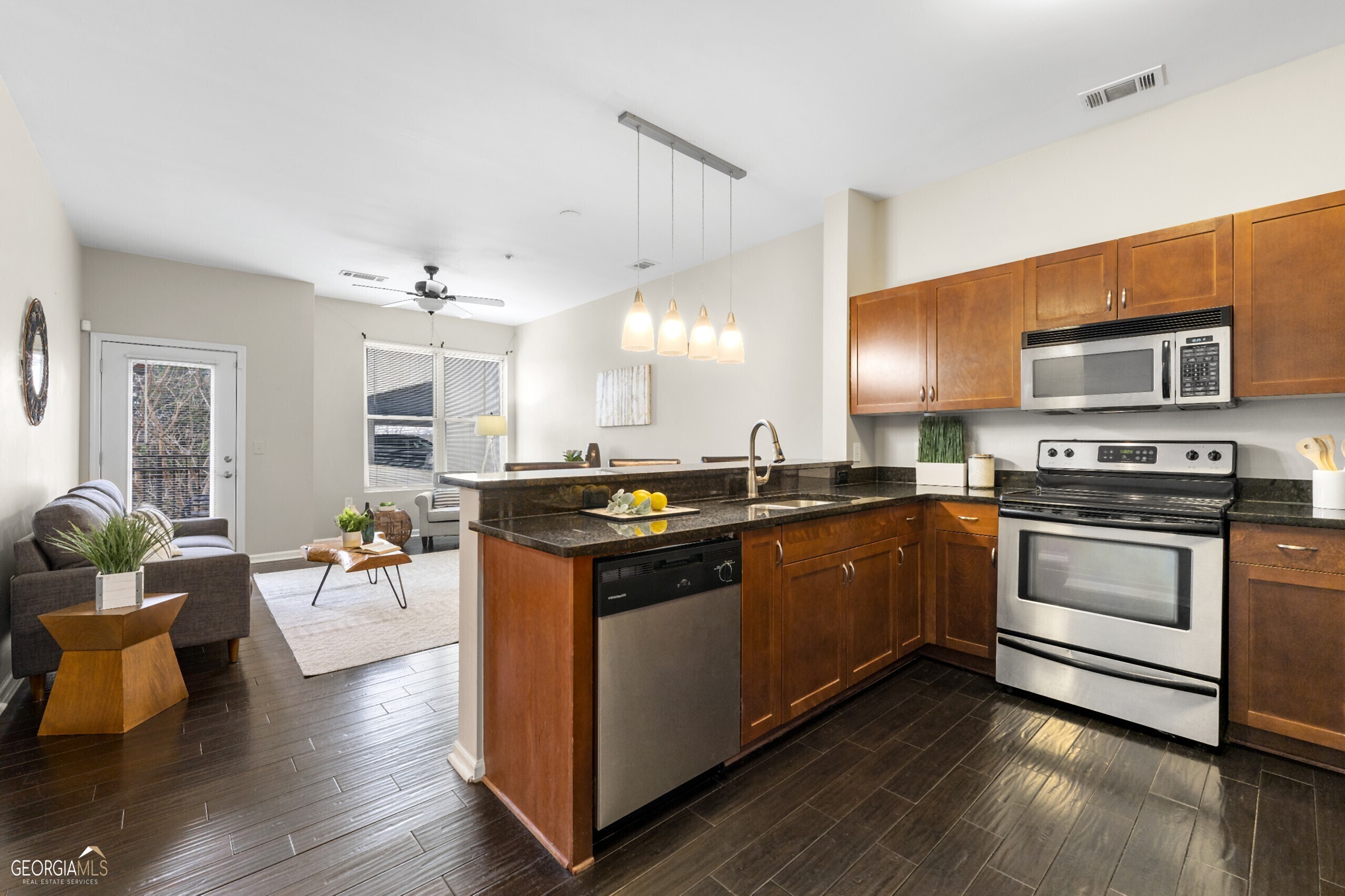 a large kitchen with stainless steel appliances and wooden floor