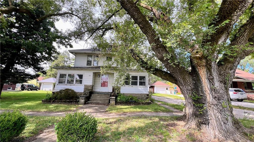 a front view of house with yard and trees around