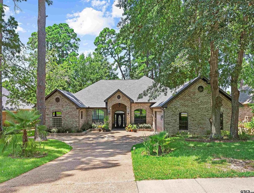 a front view of a house with a garden and trees