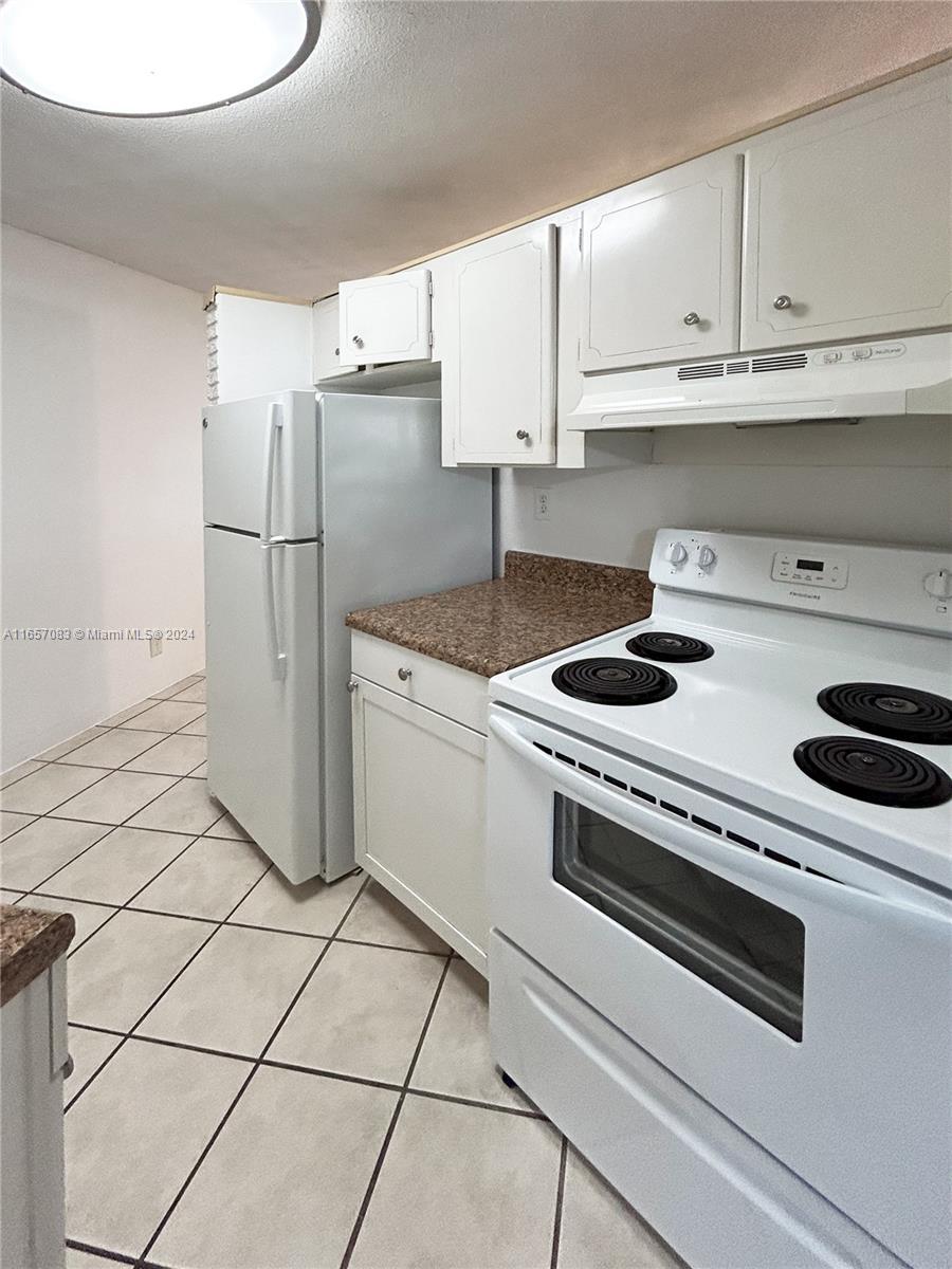 a kitchen with a stove a refrigerator and cabinets