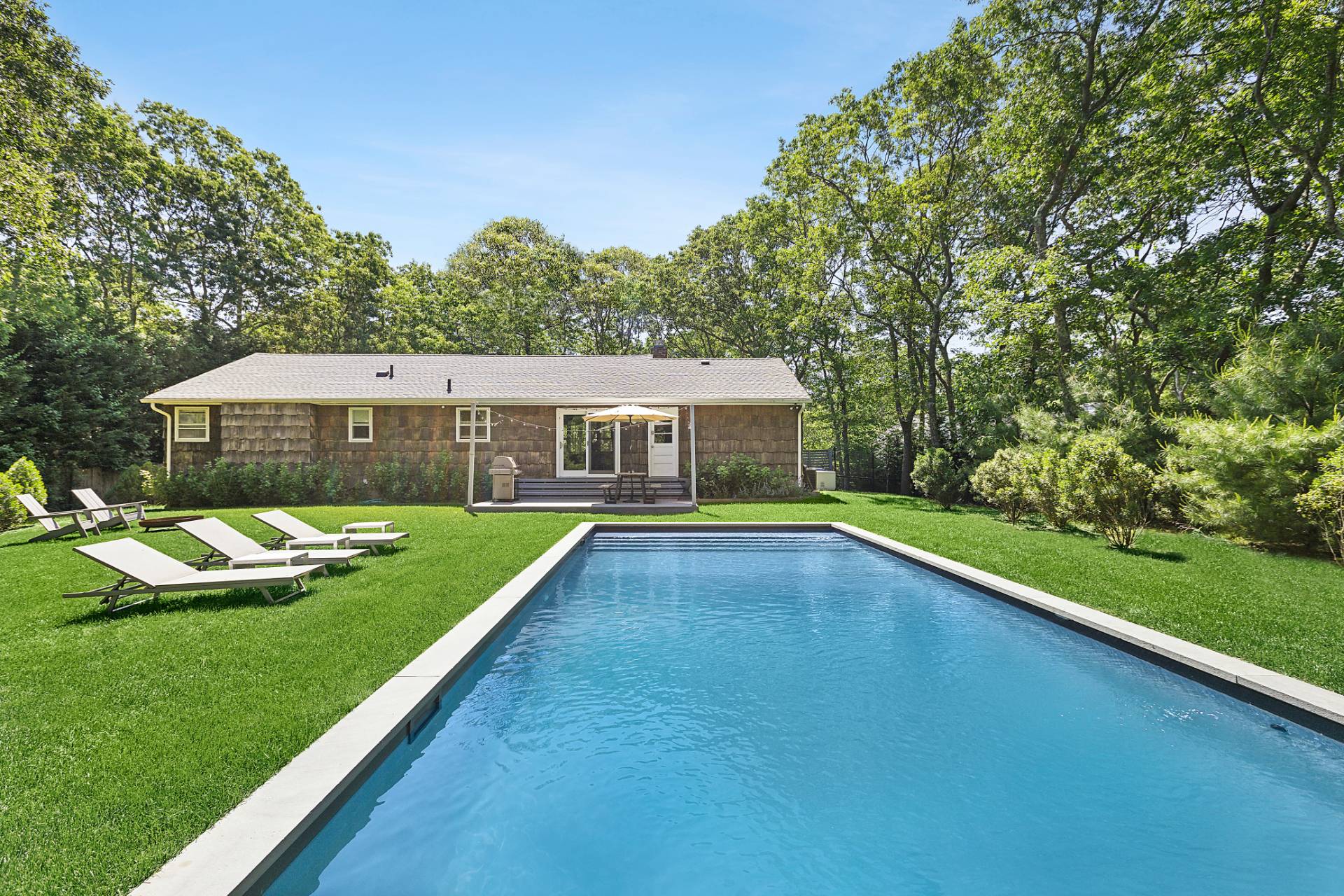 a aerial view of a house with swimming pool and yard with green space