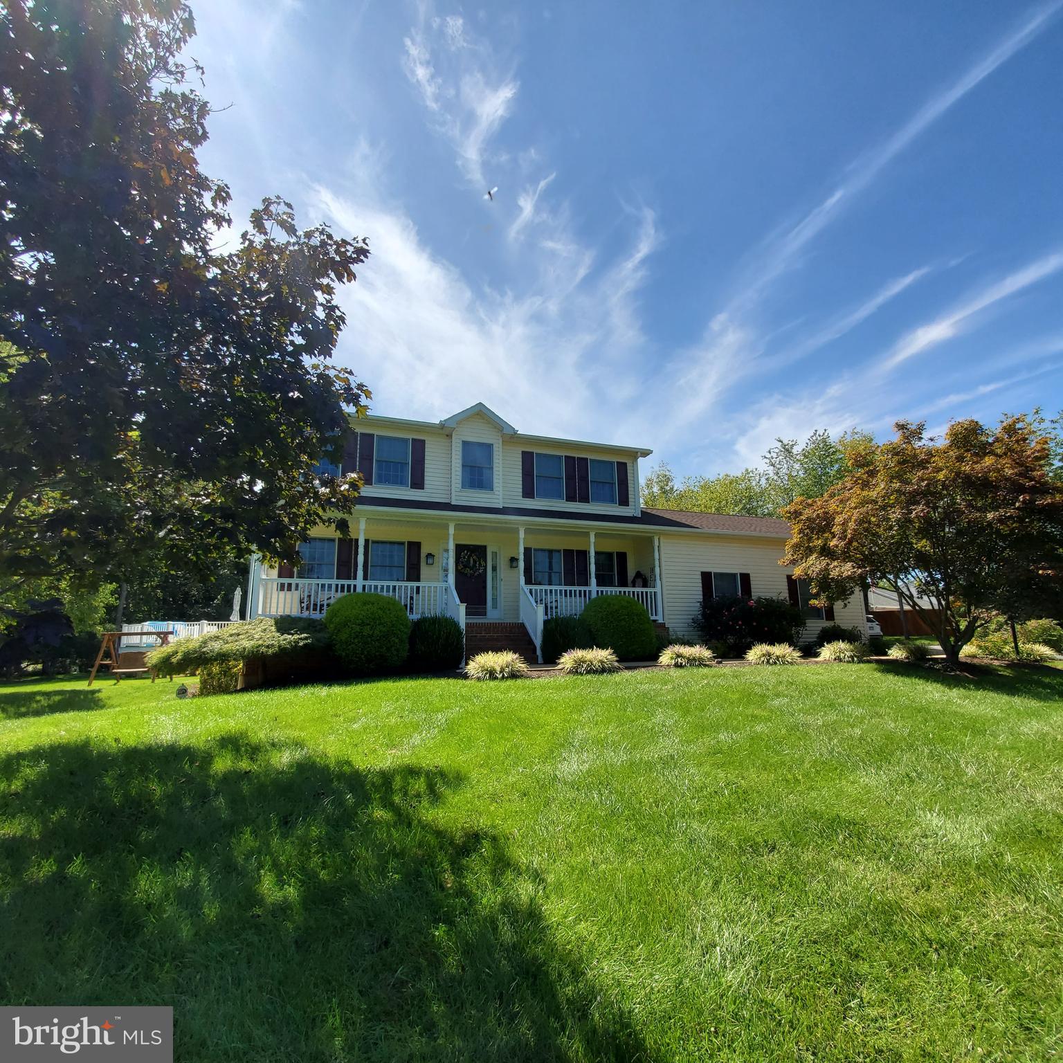 a view of a house with a big yard and large trees