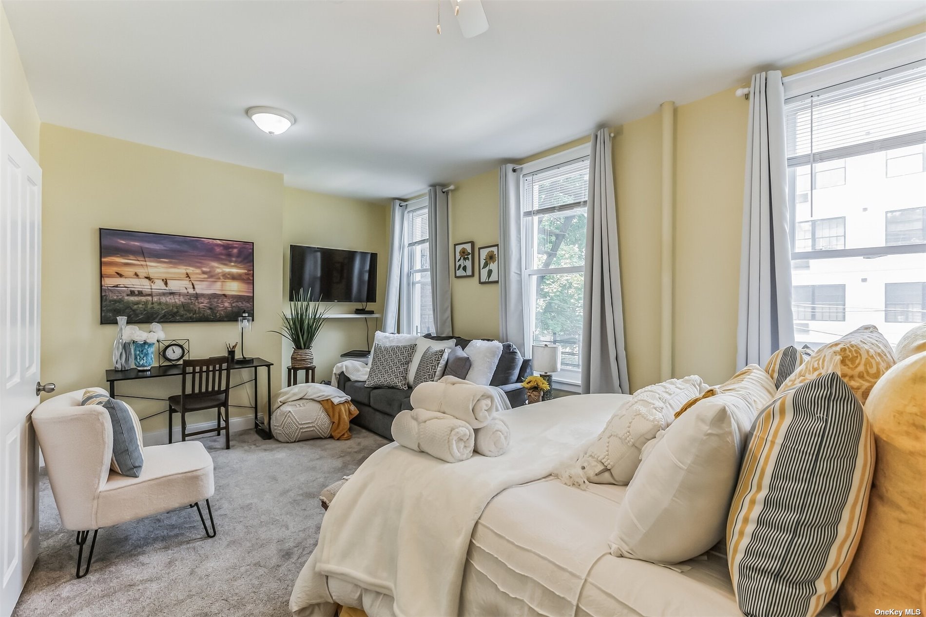 a bedroom with furniture and a large window