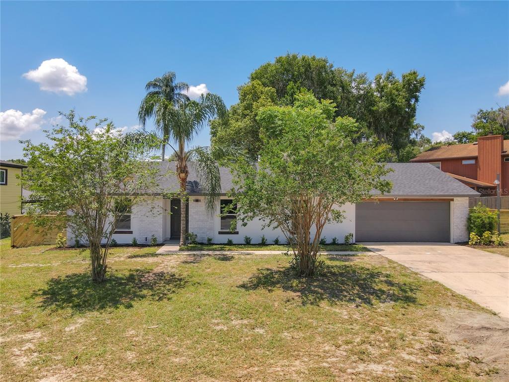 a view of a house with a yard and tree s