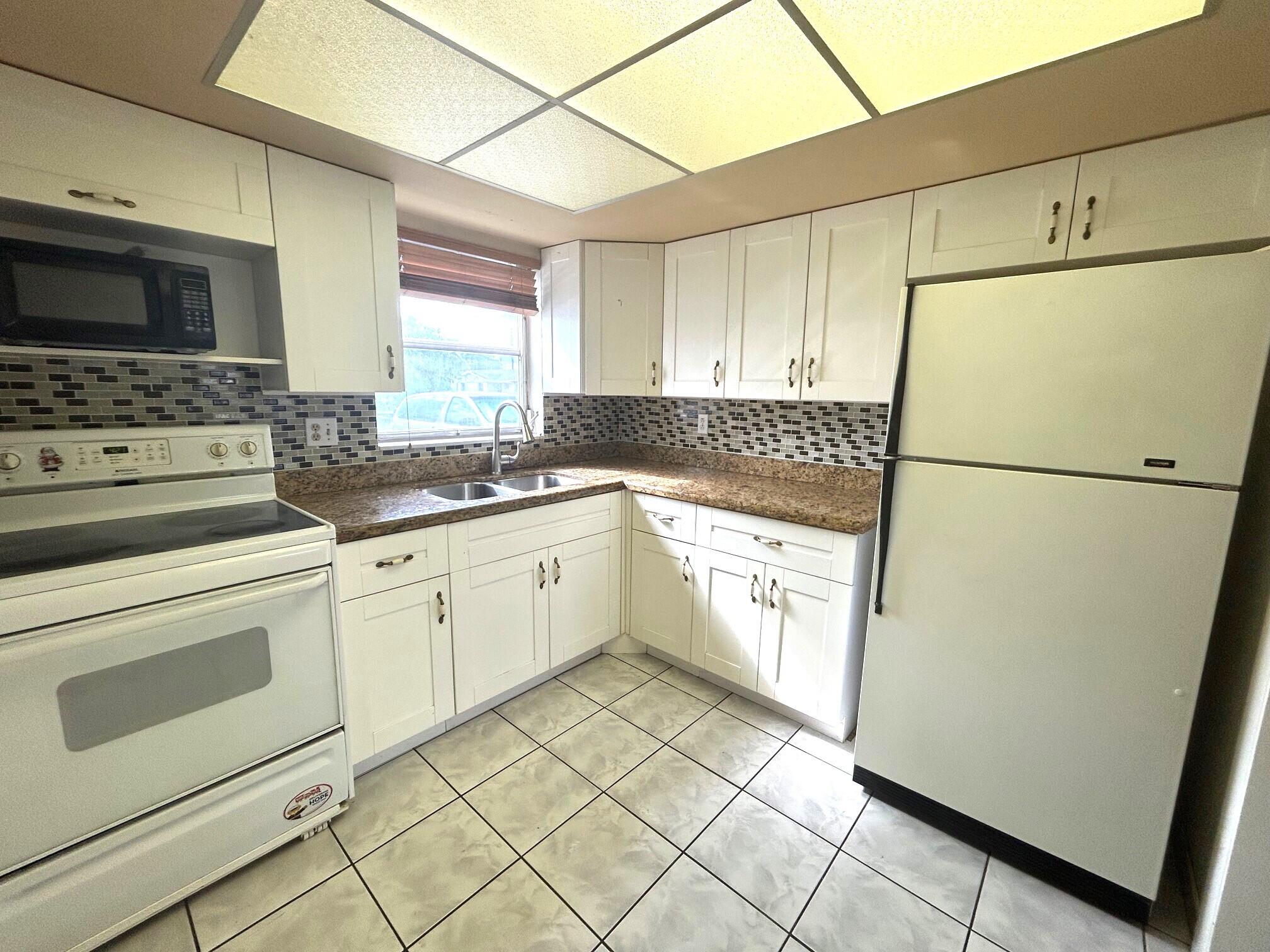 a kitchen with a refrigerator sink stove and cabinets