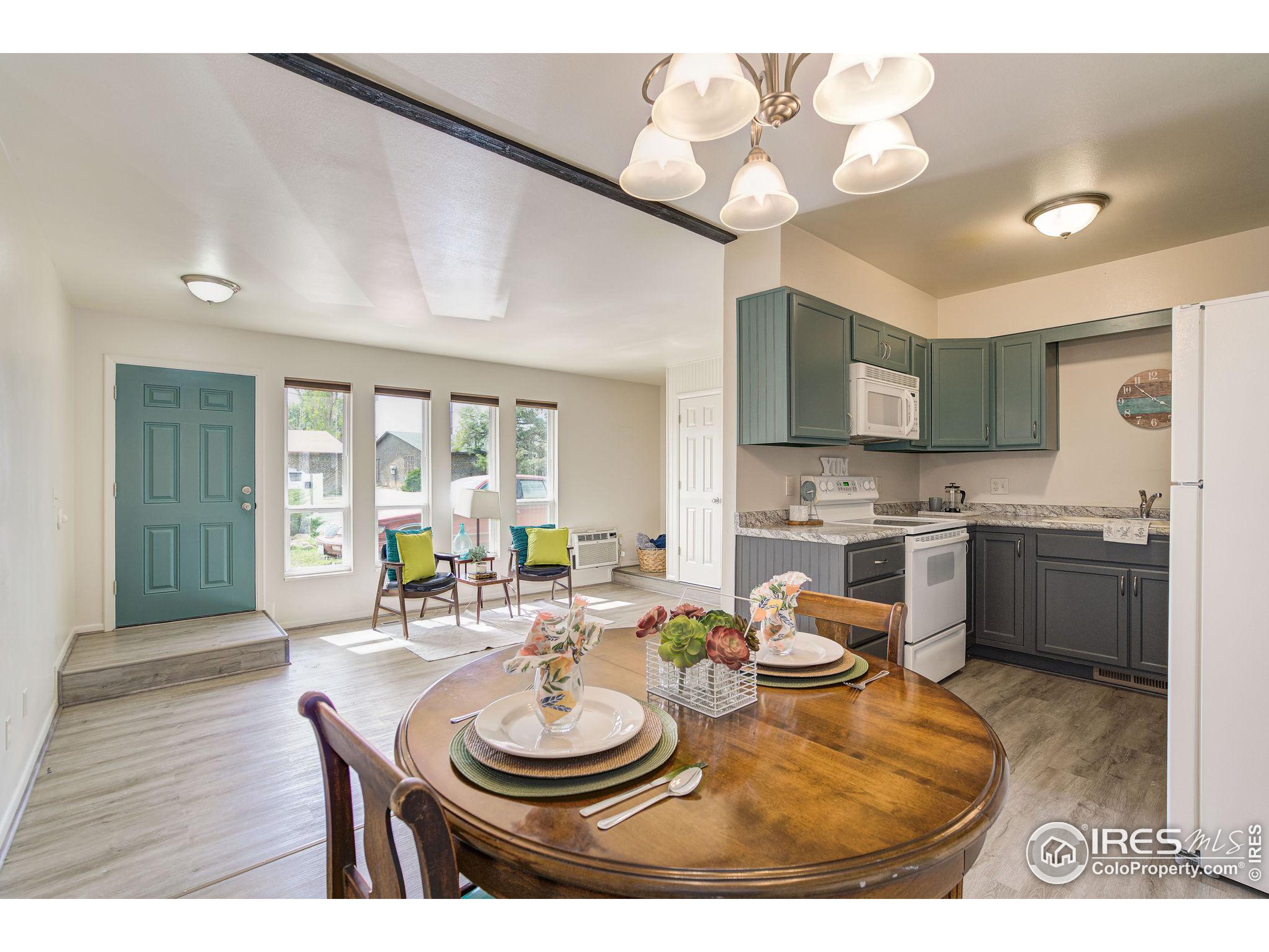 a kitchen with a dining table cabinets stainless steel appliances and a chandelier