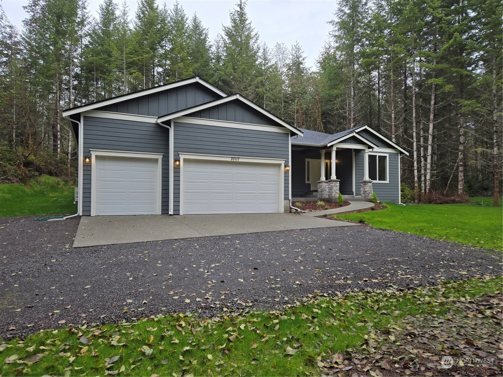 a front view of a house with a garden and trees