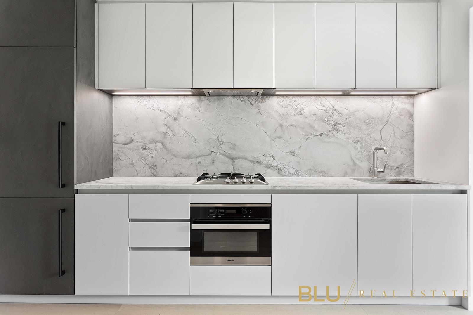 a kitchen with granite countertop white cabinets and white appliances